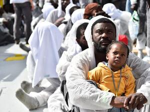 A father and daughter wait for aid distribution aboard a rescue ship, after their boat capsized off the coast of Libya. (AFP/Gabriel Bouys) A father and daughter wait for aid distribution aboard a rescue ship, after their boat capsized off the coast of Libya. (AFP/Gabriel Bouys)