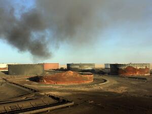 This file photo taken on January 08, 2016 shows smoke billowing from a petroleum storage tank after a fire was extinguished at Al-Sidra oil terminal, near Ras Lanuf, in the so-called "oil crescent" along Libya's northern coast. (AFP/Stringer