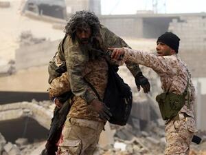 A member of the Libyan National Army (LNA) carries an injured comrade during fighting against Daesh Takfiri terrorists in the southern areas of Benghazi. (AFP/ File Photo)
