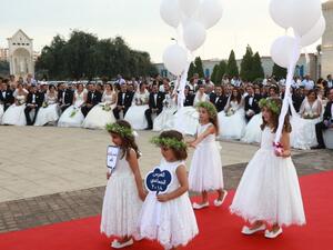 Bridemades carry balloons as Lebanese Maronite Christian couples take part in a mass wedding at the Maronite Patriarchate in Bkerke on September 2, 2018. 
ANWAR AMRO / AFP