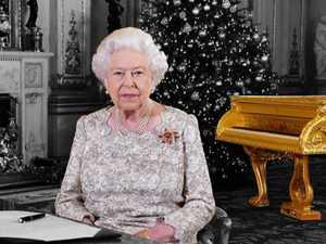 Queen Elizabeth during her Christmas annual speech with the controversial gold piano behind her. (AlBawaba)