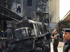 Members of the security forces and onlookers gather at the scene of a fiery train crash at the Egyptian capital Cairo's main railway station on February 27, 2019. (AFP/ Mohamed el-Shahed)