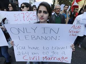 Lebanese protestors hold placards during a demonstration against the ongoing ban on civil unions in the Lebanese capital Beirut on March 1, 2015. (AFP)