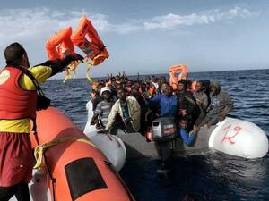 A member of Spanish humanitarian NGO Proactiva Open Arms, throws life jackets to refugees and migrants during a rescue operation off the coast of Libya on October 3, 2016. (AFP / Aris Messinis)