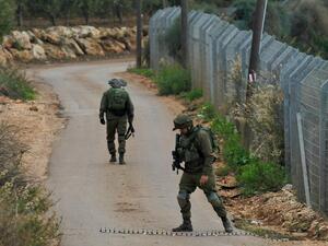 An Israeli soldier stands behind a laid-out spike strip at a security checkpoint near the northern Israeli town of Metula near the border with Lebanon on December 4. (AFP/File)