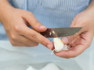 ضعي رأس الثوم على الطاولة واضغطي عليه براحة يدك بقوّة.