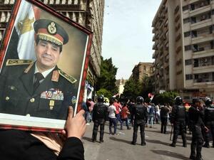A supporter of President Abdel Fattah al-Sisi carries of portrait of the Egyptian leader. (AFP/File)