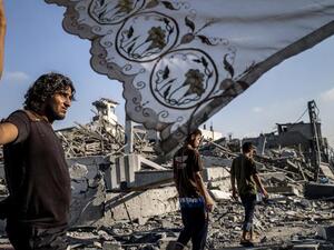 Palestinians stand next to a makeshift shelter in Gaza City on 6 August 2014. (AFP/File)