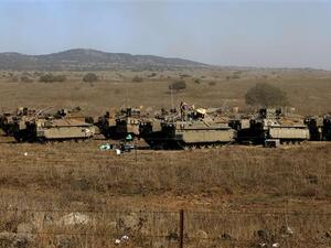Israeli soldiers stand atop armored personnel carriers stationed in the Israeli-occupied Golan Heights. (AFP/File)