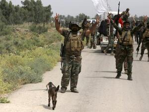 Iraqi pro-government militiamen flash the sign of victory celebrating after the liberation from Daesh militants of the village of Sayed Ghareeb, near Dujail, on Tuesday. (AFP/Mohammed Sawaf)