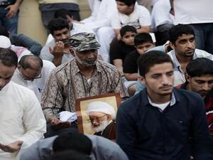 Bahraini protestors hold a placard bearing the portrait of top Bahraini Shia cleric Sheikh Issa Qassim, during a protest against the revocation of Qassim's citizenship near his house in the village of Diraz, west of Manama, on June 20, 2016. (AFP/File)