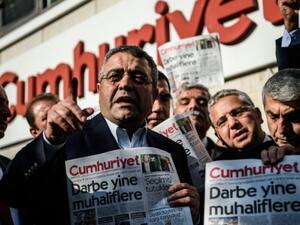 Main opposition Republic people's Party (CHP) member of parliament Sezgin Tanrikulu, left, gestures as politicians hold today's copy of Cumhuriyet newspaper in front of the newspaper's headquarters on October 31, 2016 in Istanbul. (AFP/Ozan Kose)