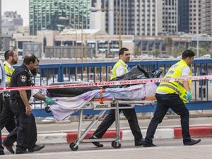 Volunteers remove the body of a Palestinian shot dead after carrying out a stabbing attack. (AFP/File)
