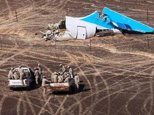 Egyptian Military members approach a plane's tail at the wreckage of a passenger jet bound for St. Petersburg in Russia that crashed in Hassana, Egypt, on Sunday. (YouTube)
