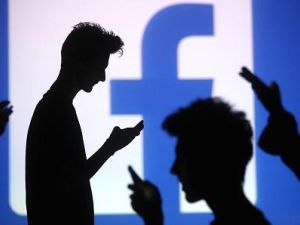 Internet users shadow a Facebook logo backdrop. (Facebook, dawn.com)