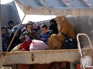 Iraqi women and children sit in the back of a truck at an army checkpoint at Ayn al-Tamer crossing at the entrance to Karbala province on January 6, 2014. (AFP/Ahmad al-Rubaye)