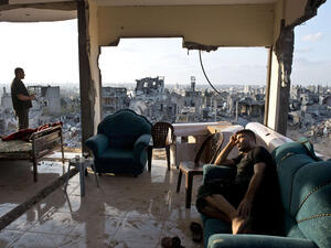 Two young men sit among the aftermath of brutal Israeli offensive on Gaza. (AFP/Roberto Schmidt)