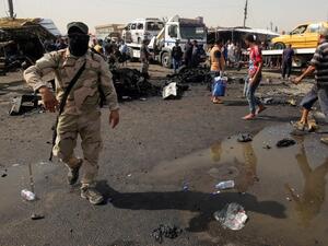 Iraqi soldiers and civilians check the damage after a suicide bomber detonated an explosives-rigged vehicle in northern Baghdad's Sadr City, May 17, 2016. (AFP/Ahmad Al-Rubaye)