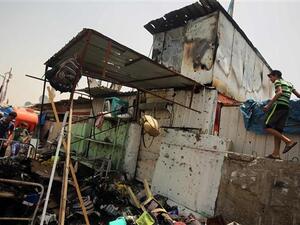 This May 11, 2016 photo shows people looking at the damage following a car bomb in Baghdad. (AFP/File)