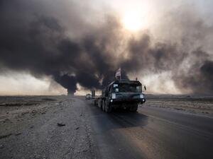 Iraqi army vehicle drives down a road east of Mosul, northern Iraq, on October 22, 2016, as displaced families flee areas of unrest during an operation to retake the city from Islamic State (IS) group jihadists. (AFP/Ahmad Al-Rubaye)