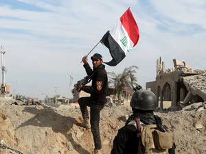 A soldier raises the Iraqi flag in Ramadi. (Twitter)