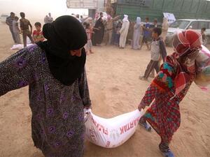 Displaced Iraqis, who fled the western city of Fallujah, carry bags of food donated by a non-government organization called Preemptive Love Coalition at a makeshift camp housing Internally Displaced Persons (IDPs) in the city of al-Khalidiyah. (AFP/File)