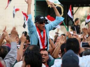 An Iraqi man chants slogans as other wave their national flag during a demonstration against corruption. (AFP/File) An Iraqi man chants slogans as other wave their national flag during a demonstration against corruption. (AFP/File)