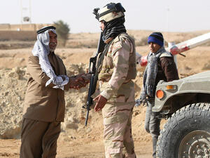 A Sunni Muslim Iraqi man shakes the hand of a soldier at Ein Tamer as families flee their homes in the city of Fallujah. (AFP/File)