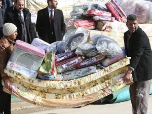 Iraqis who fled Fallujah with their families carry blankets and mattresses distributed by the International Organization for Migration (IOM). (AFP/File) 