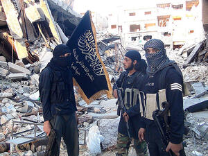 Al-Nusra Front fighters stand among destroyed buildings near the front line in Yarmouk. (AFP/File)