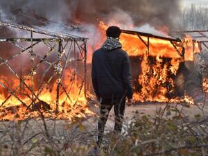 A refugee looks at shacks burning during the dismantling of half of the Jungle in Calais, France. (AFP/File)