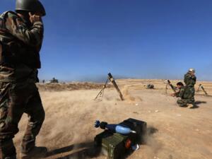Iraqi Kurdish Peshmerga fighters fire a mortar shell from the top of Mount Zardak, about 25 kilometres east of Mosul. (AFP/File)
