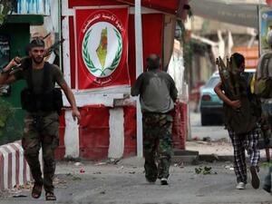 Armed men walk in the streets of Ain al-Hilweh Palestinian refugee camp near Lebanon's southern port city of Sidon following clashes on August 22, 2015. (AFP/File)
