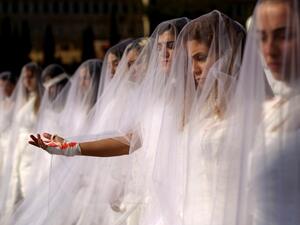 Activists from NGO Abaad dressed as brides and wearing injury patches, protest in downtown Beirut on 6 December 2016. (AFP/File)