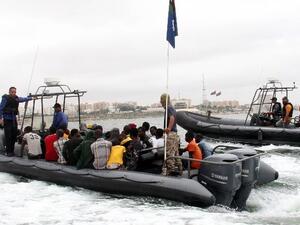 Migrants sit on a boat of Libyan coastguard taking them ashore after they were rescued off the town of Qarabulli. (AFP/File)