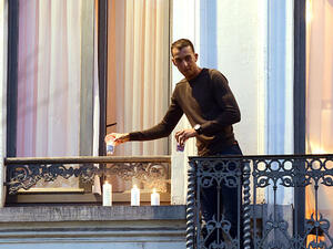 Mohamed, brother of the two suspected extremists responsible for the Paris attacks, placing lit candles on the balcony of his home during a vigil for the Paris victims. (AFP/File)