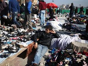 A Palestinian boy sits amidst used clothes and items at the weekly flea market in the Nusseirat Refugee Camp, central Gaza Strip, on February 29. (AFP/File)