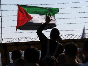 A Palestinian flag is attached to the barbed wires of Israel's Ofer prison in West Bank. (AFP/File)