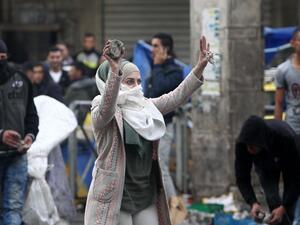A young woman shows stones during clashes with Israeli forces in Hebron October 7, 2015. (AFP/Hazem Bader) 