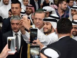 This December 2, 2015 photo released by Qatar University shows Qataris taking pictures with Turkish President Recep Tayyip Erdogan. (AFP/File)
