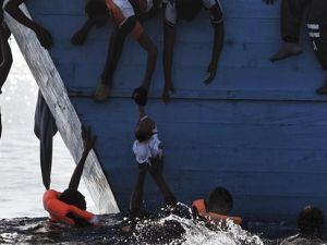 Refugees try to pull a child out of the water as they wait to be rescued by members of Proactiva Open Arms NGO in the Mediterranean sea, some 12 nautical miles north of Libya, on October 4, 2016. (AFP/File)
