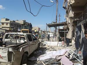 Iraqis stand at the site of a car bomb explosion in Sadr City in northern Baghdad. (AFP/File)