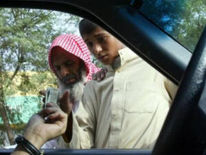 A driver hands money to beggars in Riyadh. (AFP/File)