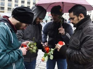 Syrian refugees light candles to place them outside the French embassy to Germany in Berlin on November 15, 2015 for victims of the November 13 attacks in Paris. (AFP Photo/Tobias Schwarz)