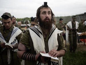 Religious soldiers of the Netzah Yehuda Battalion pray while completing the final stages of a 40 kilometer journey in 2010. (Abir Sultan/Flash90)