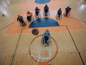 A Palestinian woman takes a shot during a wheelchair basketball coaching session, headed by US coach Jess Markt, in Khan Younis in the southern Gaza strip on May 28, 2016. (AFP/Said Khatib)