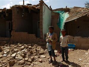 Yemeni children stand outside houses which were destroyed several months ago in an airstrike by Saudi warplanes at a slum in Sana'a, March 12, 2016. (AFP/File)