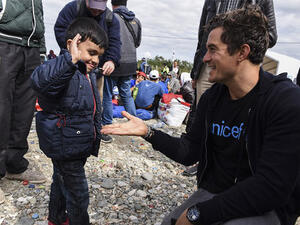 Hollywood actor Orlando Bloom laughs and snaps selfies with children as he visits a Syrian refugee camp in Macedonia. (AFP)