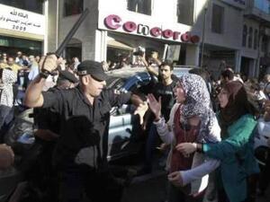 صورة عن الفيسبوك لرجل شرطة يهدد احدى المتظاهرات