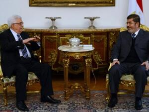 الرئيسان المصري محمد مرسي والفلسطيني محمود عباس خلال اجتماع في القاهرة سبق لقاء فتح حماس/أ.ف.ب
